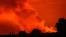 Siluet dua orang terlihat saat langit malam berubah menjadi merah akibat letusan Gunung Nyiragongo, di Goma, Kongo, Sabtu (22/5/2021). Gunung berapi Nyiragongo meletus pada Sabtu (22/5) malam memicu warga kota Goma melarikan diri menuju perbatasan dengan Rwanda. (AP Photo/Justin Kabumba)