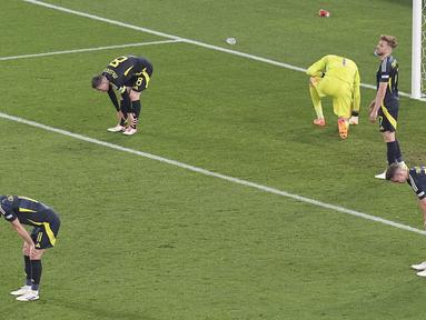 Para pemain Skotlandia tertunduk lesu setelah ditaklukkan Hungaria pada laga Grup A Euro 2024 di Stuttgart Stadium, Senin (24/6/2024). Pasukan Tartan dipaksa menyerah 0-1. (AP Photo/Ariel Schalit)