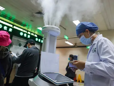 Staf medis menggunakan komputer tablet untuk mengendalikan robot pintar di ruang rawat jalan Rumah Sakit Renmin Universitas Wuhan di Wuhan, 16 Maret 2020. Robot pintar itu mampu melakukan pekerjaan disinfeksi secara otomatis di sejumlah lokasi yang telah ditentukan satu per satu. (Xinhua/Shen Bohan)