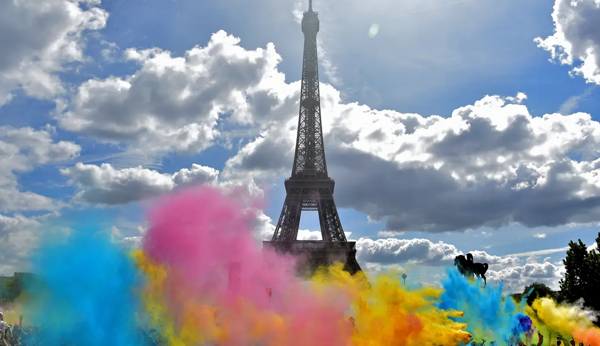 Bermacam serbuk warna bertebaran saat acara Color Run 2017 di depan Menara Eiffel, Paris, Minggu (16/4). Lomba lari sepanjang 5 km tanpa hadiah itu diikuti ribuan peserta. (AFP PHOTO / CHRISTOPHE ARCHAMBAULT)