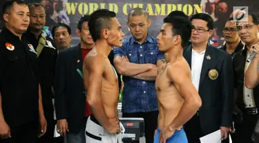 Petinju Indonesia Tibo Monabesa (kiri depan) bertatapan dengan Arnold Garde (Filipina) usai melakukan timbang badan di GOR Cendrawasih, Jakarta, Jumat (19/5). Tibo akan mempertahankan gelar WBC Internasional Silver. (Liputan6.com/Helmi Fithriansyah)