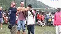 Turis asing mencoba menggunakan busur panah tradisional Suku Dani dalam Festival Budaya Lembah Baliem Wamena yang digelar di Wosilimo, Distrik Kurulu, Kabupaten Jayawijaya, Papua.