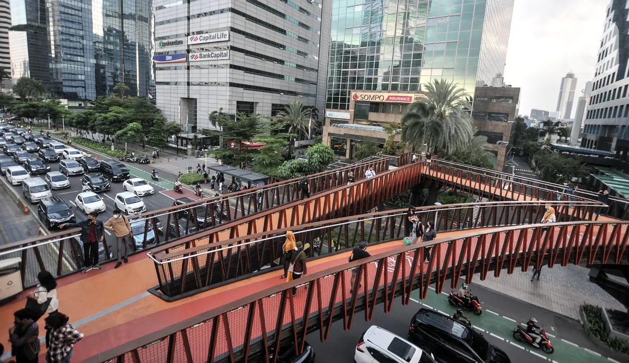 Warga ngabuburit di JPO Pinisi Pinisi Karet-Sudirman, Jakarta Pusat, Senin (4/4/2022). JPO Pinisi kini menjadi destinasi baru warga Jakarta untuk menunggu waktu berbuka puasa atau ngabuburit sambil menikmati suasana perkotaan. (merdeka.com/Iqbal S. Nugroho)