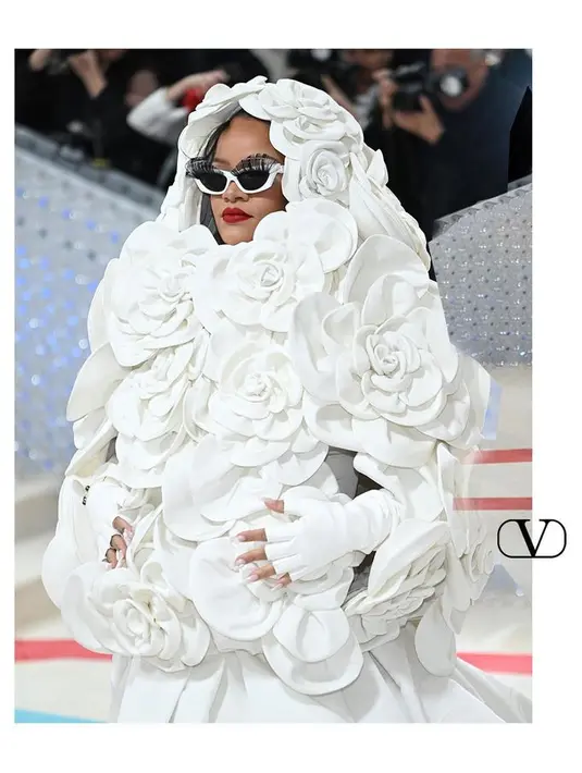 Rihanna memakai gaun sutra dan jubah dengan detail bunga kamelia dari Valentino. [@maisonvalentino]