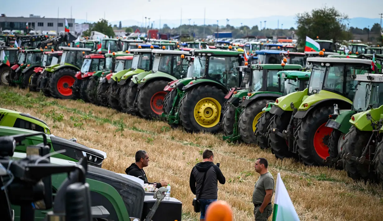 Para petani berdiri di depan traktor mereka dalam sebuah protes menentang pencabutan larangan impor biji-bijian yang berasal dari Ukraina, di Dolni Bogrov, dekat Sofia, pada tanggal 19 September 2023. (Nikolay DOYCHINOV/AFP)