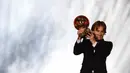 Gelandang Real Madrid asal Kroasia, Luka Modric, menunjukan trofi saat malam penghargaan Ballon d'Or di Paris, Senin (3/12). Dirinya berhasil meraih gelar Ballon d'Or. (AFP/Franck Fife)