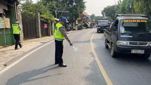 Anggota Polres Metro Depok melakukan cek TKP usai kecelakaan antara pengendara motor dengan ambulance RS Citra Arafiq, Jalan Raya Muchtar, Sawangan, Depok.