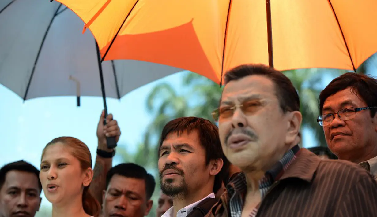 Walikota Manila yang juga mantan presiden Filipina, Joseph Estrada (kedua dari kanan) turut menyambut kedatangan Manny Pacquiao. (AFP PHOTO/NOEL CELIS)
