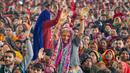 Umat Hindu menari saat mereka mendengarkan seorang pemimpin agama pada Festival Magh Mela di Sangam, pertemuan Sungai Gangga - Sungai Yamuna, Prayagraj, Uttar Pradesh, India, 31 Januari 2023. Ratusan ribu peziarah Hindu diperkirakan akan berenang dalam pertemuan tersebut, berharap bisa menghapus dosa selama festival sebulan penuh. (AP Photo/Rajesh Kumar Singh)
