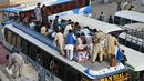 Penumpang yang duduk di atas bus menunggu keberangkatan bus mereka di terminal bus di Lahore pada 19 April 2023, saat orang-orang menuju kampung halaman mereka untuk merayakan Hari Raya Idul Fitri, yang menandai berakhirnya bulan puasa Ramadhan. (Photo by Arif Ali / AFP)