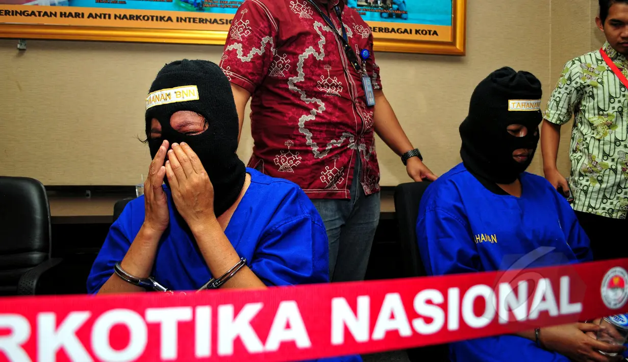 Salah satu kurir sabu, SA (kiri), menangis saat rilis barang bukti dan tersangka di Kantor BNN, Jakarta, Selasa (19/5/2015). SA dan AN ditangkap aparat BNN dengan barang bukti 12,29 kilogram sabu. (Liputan6.com/Yoppy Renato)