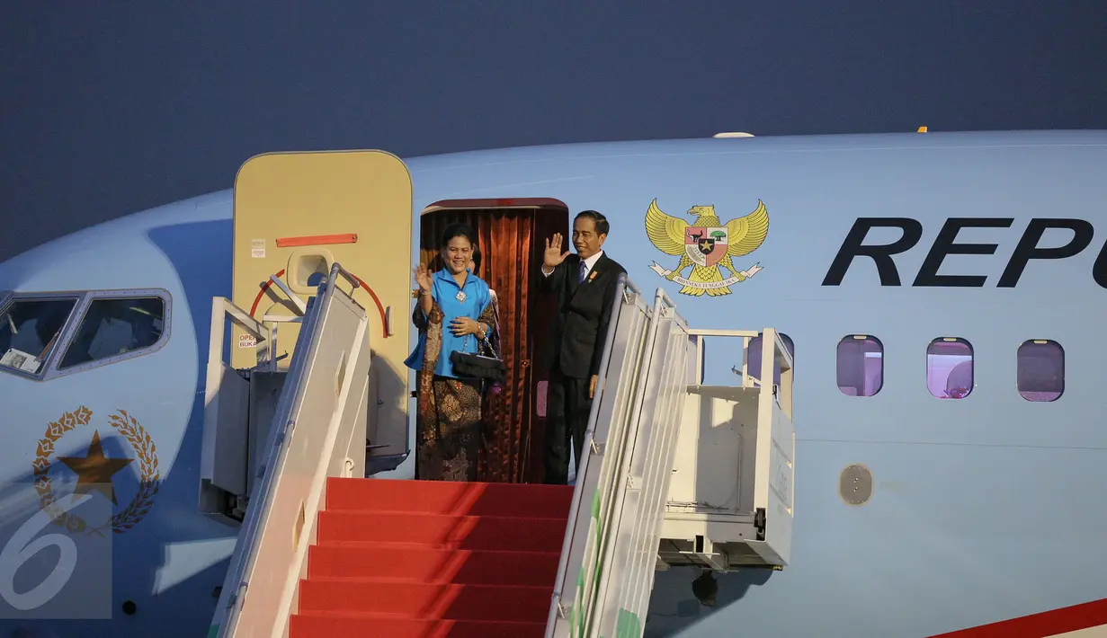 Presiden Jokowi (kiri) didampingi Ibu Negara Iriana Widodo melambaikan tangan di Bandara Udara Halim Perdana Kusuma, Jakarta, (20/11/). Kepergian Presiden ke Malaysia untuk menghadiri Konferensi Tingkat Tinggi (KTT) ke-27. (Liputan6.com/Faizal Fanani)