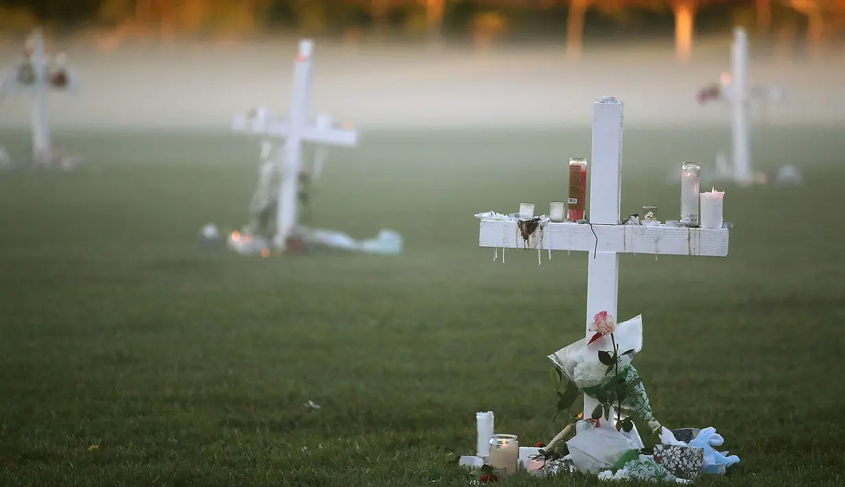 Lilin ditempatkan pada salib untuk menghormati korban pembunuhan massal di Sekolah Marjory Stoneman Douglas, Pine Trail Park, Florida (16/2). Polisi menangkap mantan mahasiswa Nikolas Cruz (19) karena membunuh 17 orang. (Mark Wilson / Getty Images / AFP)