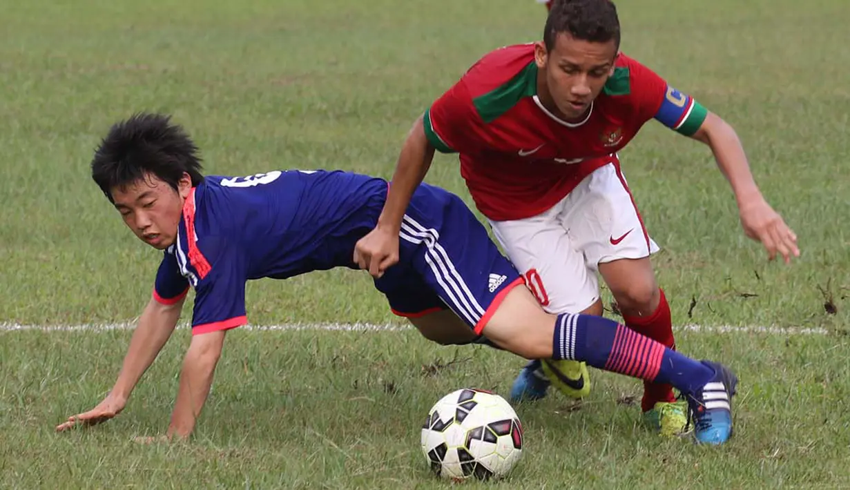 Pemain Indonesia U16 berebut bola dengan pemain  Jepang U16 dalam ujicoba yang digelar di Lapangan Padepokan Voli Indonesia, Sentul, Bogor. Selasa (15/4)
