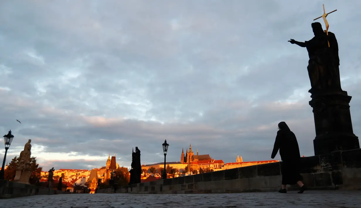 Seorang biarawati melintasi Jembatan Charles yang dibangun pada abad pertengahan di Praha, Republik Ceko, Kamis (8/10/2020). Republik Ceko pada Rabu (7/10) melaporkan sebanyak 5.335 kasus virus corona baru yang dikonfirmasi di negara itu, melampaui rekor hari sebelumnya. (AP Photo/Petr David Josek)