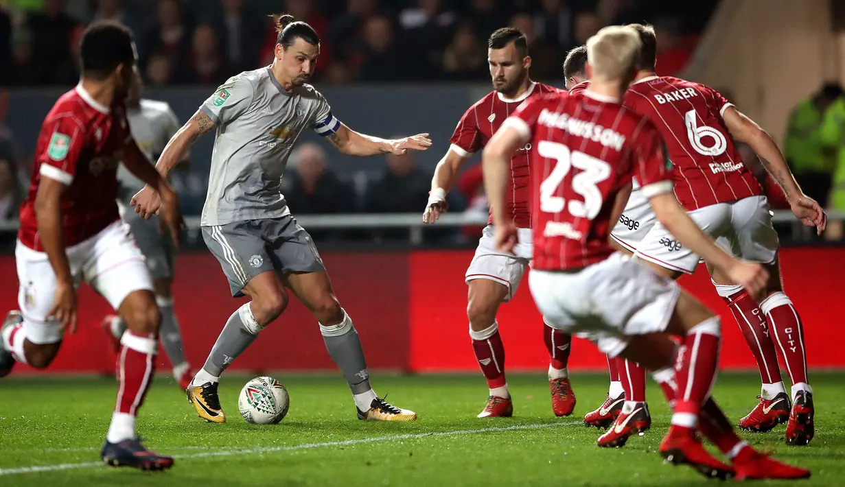 Pemain Manchester United, Zlatan Ibrahimovic menggiring bola dengan kawalan pemain Bristol City pada perempat final Piala Liga Inggris di Ashton Gate, Kamis (21/12). MU tersingkir setelah takluk 1-2 di kandang Bristol City. (Nick Potts/PA via AP)