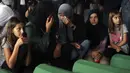 Wanita muslim berdoa dekat peti mati kerabat mereka yang menjadi korban genosida Srebrenica 1995 di Potocari, Bosnia, 8 Juli 2022. Sebanyak 50 jenazah korban genosida Srebrenica yang baru diidentifikasi, satu-satunya genosida yang diakui di Eropa sejak Perang Dunia II, tiba di Memorial Center di Potocari di mana mereka akan dimakamkan pada 11 Juli. (AP Photo/Armin Durgut)