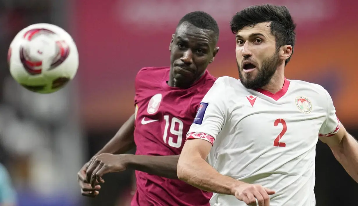 Pemain Qatar, Almoez Ali, berebut bola dengan pemain Tajikistan, Zoir Dzhuraboev, pada laga Grup A Piala Asia di Stadion Al Bayt , Rabu (17/1/2024). (AP Photo/Aijaz Rahi)