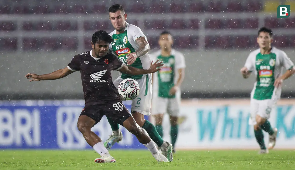Pemain PSM Makassar, Ilham Udin Armaiyn (kiri) berebut bola dengan pemain PSS Sleman, Aaron Michael Evans dalam laga pekan ke-12 BRI Liga 1 2021/2022 di Stadion Manahan, Solo, Kamis (18/11/2021). (Bola.com/Bagaskara Lazuardi)