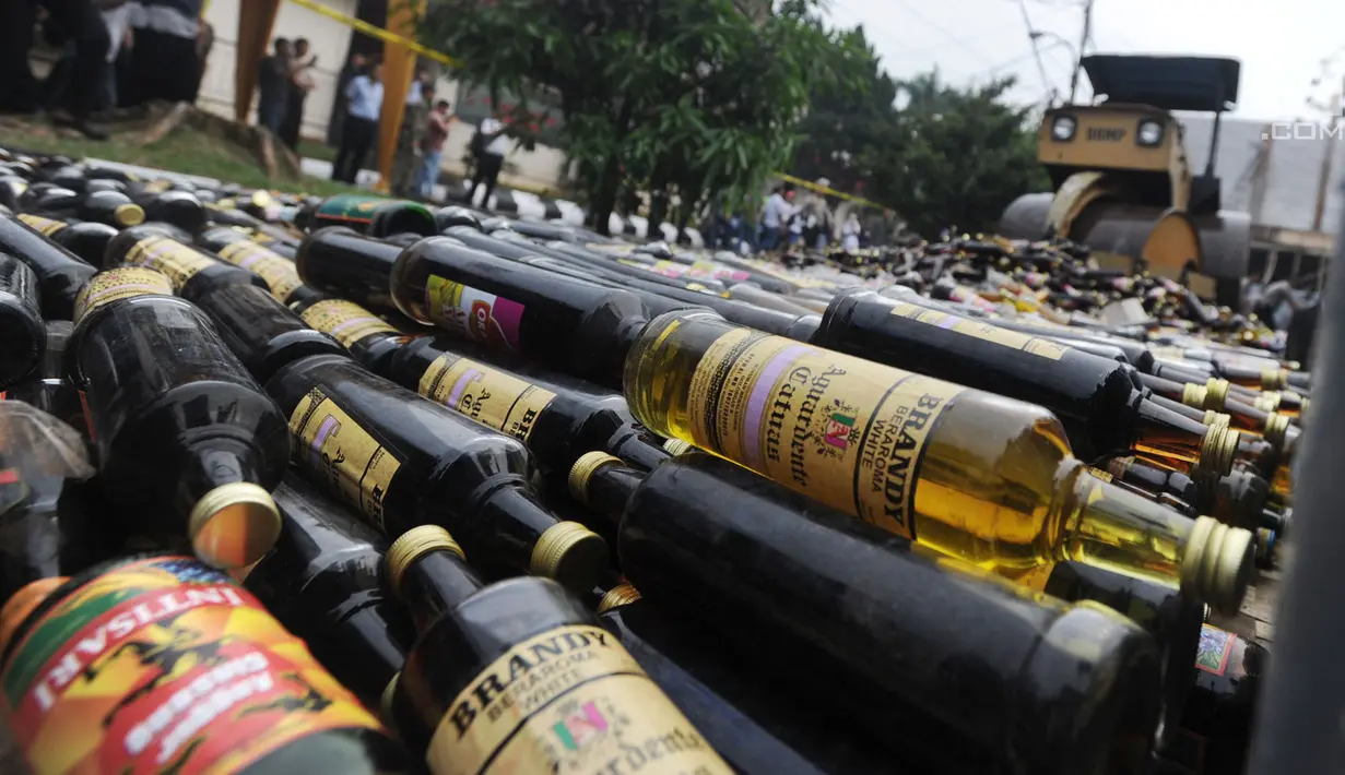 Alat berat menggilas ribuan botol minuman keras  (miras) hasil sitaan polisi di halaman Polres Bogor, Cibinong, Kamis (17/5). Miras yang dimusnahkan lebih dari 32 ribu botol, baik lokal maupun impor dengan beragam merek. (Merdeka.com/Arie Basuki)