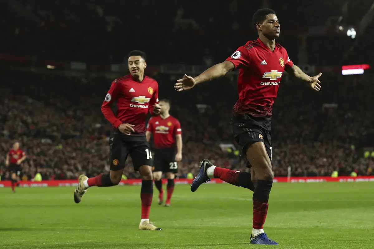 Striker Manchester United, Marcus Rashford, merayakan gol yang dicetaknya ke gawang Bournemouth pada laga Premier League di Stadion Old Trafford, Manchester, Minggu (30/12). MU menang 4-1 atas Bournemouth. (AP/Martin Rickett)