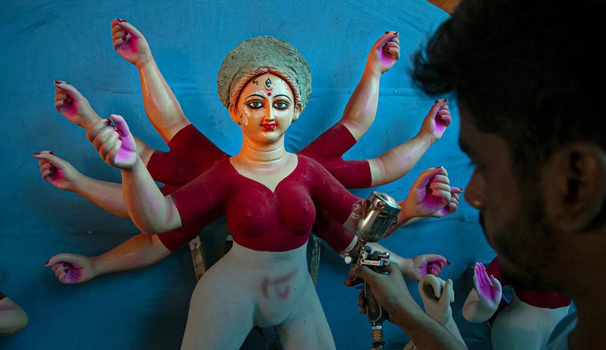 Seniman membuat patung Dewi Durga jelang Festival Durga Puja di Gauhati, India, Jumat (16/10/2020). Para pejabat kesehatan memperingatkan tentang potensi penyebaran COVID-19 selama musim festival keagamaan dengan pertemuan besar di kuil dan distrik perbelanjaan. (AP Photo/Anupam Nath)