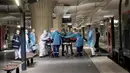 Petugas medis membawa pasien virus corona COVID-19 di Stasiun Gare d'Austerlitz di Paris, Prancis, Rabu (1/4/2020). Pasien COVID-19 dievakuasi menggunakan kereta kecepatan tinggi dari rumah sakit di Paris ke rumah sakit di Brittany dimana kasus tersebut masih terbatas. (Thomas SAMSON/AFP/POOL)