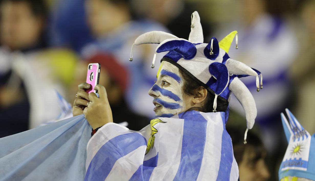 Suporter Uruguay mengambil gambar dengan smartphone saat timnya melawan Argentina  pada laga kualifikasi Piala Dunia 2018 di Montevideo, Uruguay, (31/8/2017). Argentina bermain imbang 0-0. (AP/Natacha Pisarenko)