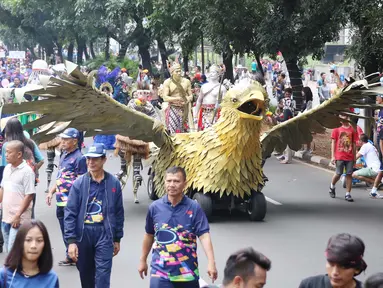 Sejumlah masyarakat mengenakan pakaian adat dan melakukan karnaval di jalan Pintu 1 Senayan, Jakarta, Minggu (24/9). Karnaval tersebut dilakukan dalam rangka HUT Gelora Bungkarno yang ke-55. (Liputan6.com/Angga Yuniar)