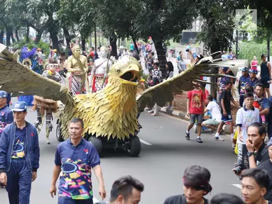 Sejumlah masyarakat mengenakan pakaian adat dan melakukan karnaval di jalan Pintu 1 Senayan, Jakarta, Minggu (24/9). Karnaval tersebut dilakukan dalam rangka HUT Gelora Bungkarno yang ke-55. (Liputan6.com/Angga Yuniar)
