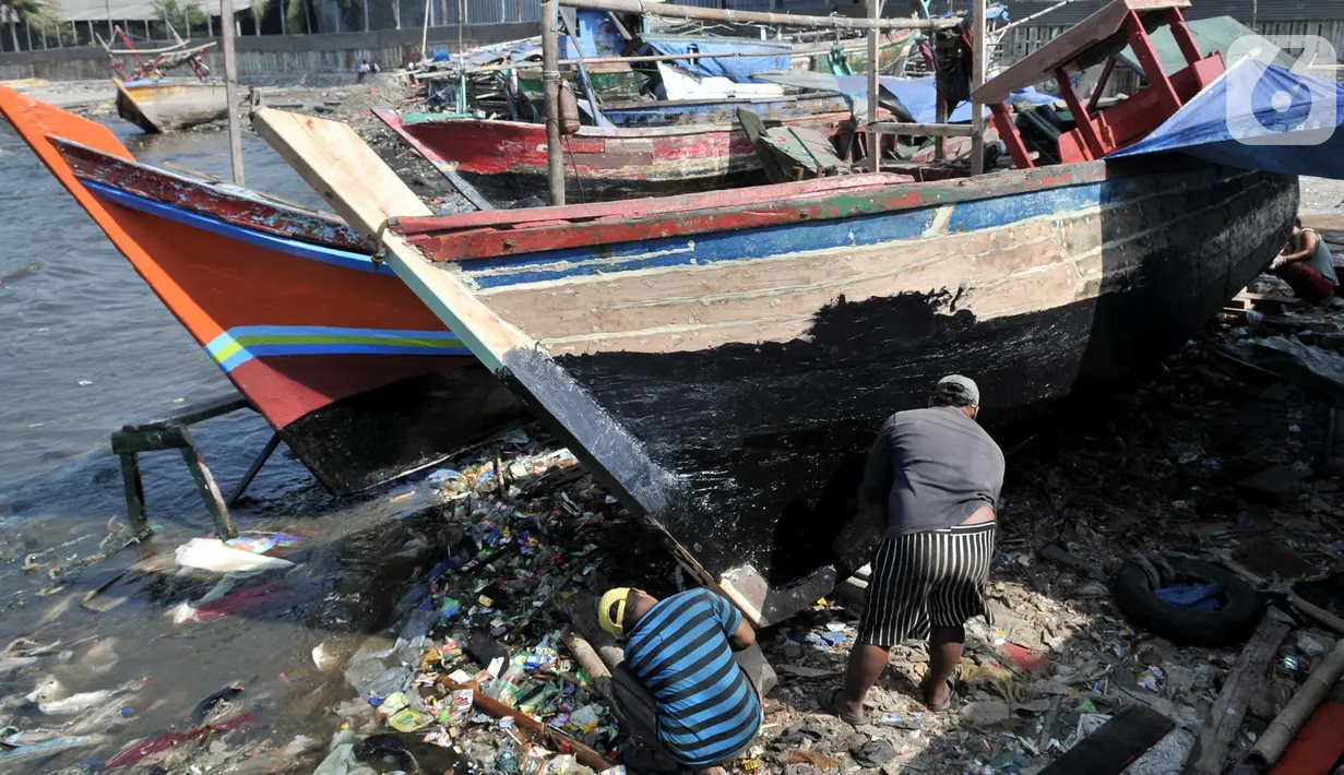 Pekerja menyelesaikan proses perbaikan kapal nelayan di pesisir Marunda, Jakarta, Selasa (22/10/2019). Jasa perbaikan kapal nelayan merupakan salah satu mata pencaharian utama warga pesisir Marunda selain mencari ikan di laut. (merdeka.com/Iqbal Nugroho)