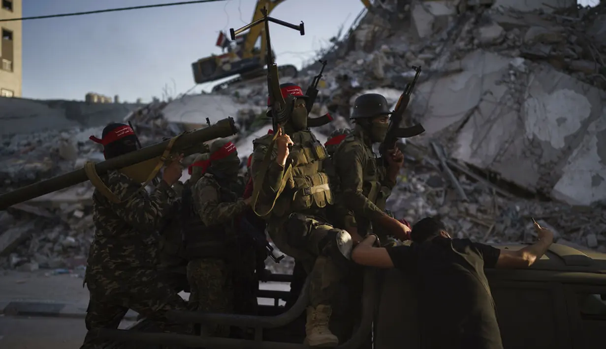 Militan Front Demokratik untuk Pembebasan Palestina (DFLP) naik pickup saat berparade di jalanan Kota Gaza, Selasa (8/6/2021). Gencatan senjata mengakhiri perang 11 hari antara Hamas sebagai penguasa Gaza dengan Israel. (AP Photo/Felipe Dana)