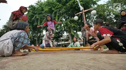 Anak-anak bermain permainan tradisional rangku alu di RPTRA Melati Duri Pulo, Jakarta, Sabtu (13/10). Traditional Games Returns (TGR) mengampanyekan permainan tradisional dengan mengusung tema "Millenials". (Liputan6.com/Herman Zakharia)