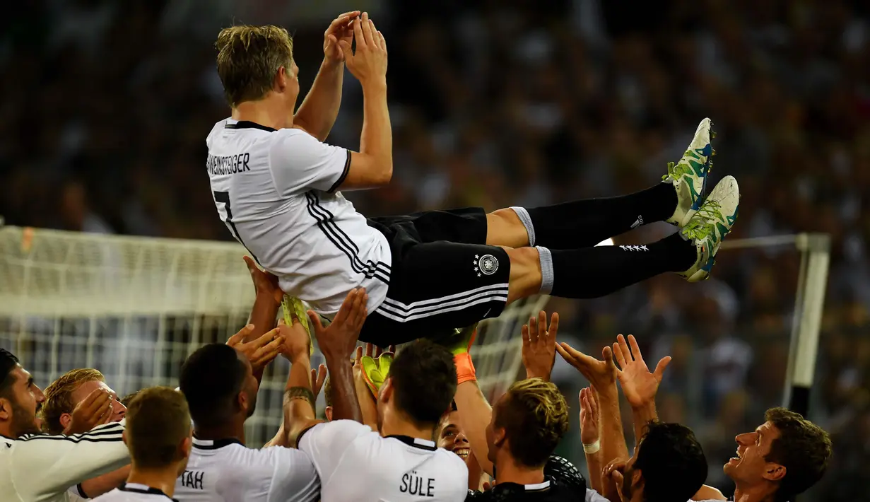 Bastian Schweinsteiger dilempar rekan-rekannya usai laga Jerman melawan Finlandia di Monchengladbach, Jerman (1/9/2016) dini hari WIB. Jerman menang 2-0. (AFP/Patrik Stollarz)