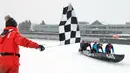 Tim Volvo yang dilewati oleh Benoit Gilbert mendapatkan bendera kotak-kotak untuk memenangkan perlombaan kano es Karnaval Musim Dingin Quebec melintasi Sungai St. Lawrence di Kota Quebec, Kanada, 5 Februari 2023. Tim Chateau Frontenac, dilewati oleh Jean Anderson (belakang), menempati posisi kedua. (Jacques Boissinot/The Canadian Press via AP)