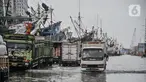 Aktivitas pekerja bongkar muatan kapal saat banjir rob di Pelabuhan Sunda Kelapa, Jakarta, Senin (6/12/2021). Banjir rob kembali merendam kawasan Pelabuhan Sunda Kelapa sejak pagi tadi hingga ketinggian 70 cm dan menyebabkan terganggunya aktivitas bongkar muatan kapal. (merdeka.com/Iqbal S Nugroho)