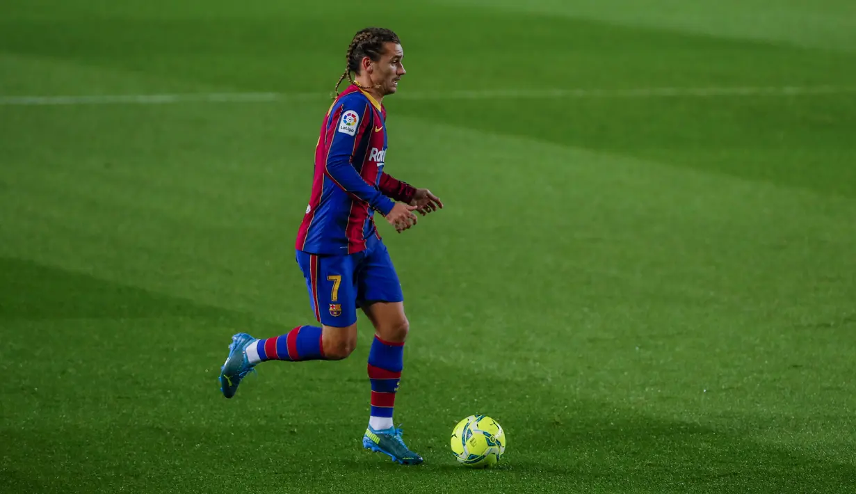 Penyerang Barcelona, Antoine Griezmann menggiring bola saat berhadapan dengan Real Sociedad pada pertandingan lanjutan La Liga Spanyol di stadion Camp Nou di Barcelona, Spanyol, Kamis (17/12/2020). Griezmann megepang dua rambutnya bisa jadi dia mulai bahagia di Barcelona. (AP Photo/Joan Monfort)