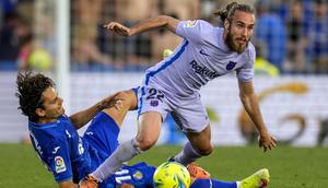 Pemain Barcelona Oscar Mingueza (kanan) berebut bola dengan pemain Getafe Enes Unal pada pertandingan sepak bola La Liga di Stadion Coliseum Alfonso Perez, Getafe, Spanyol, 15 Mei 2022. Pertandingan berakhir imbang 0-0. (AP Photo/Manu Fernandez)