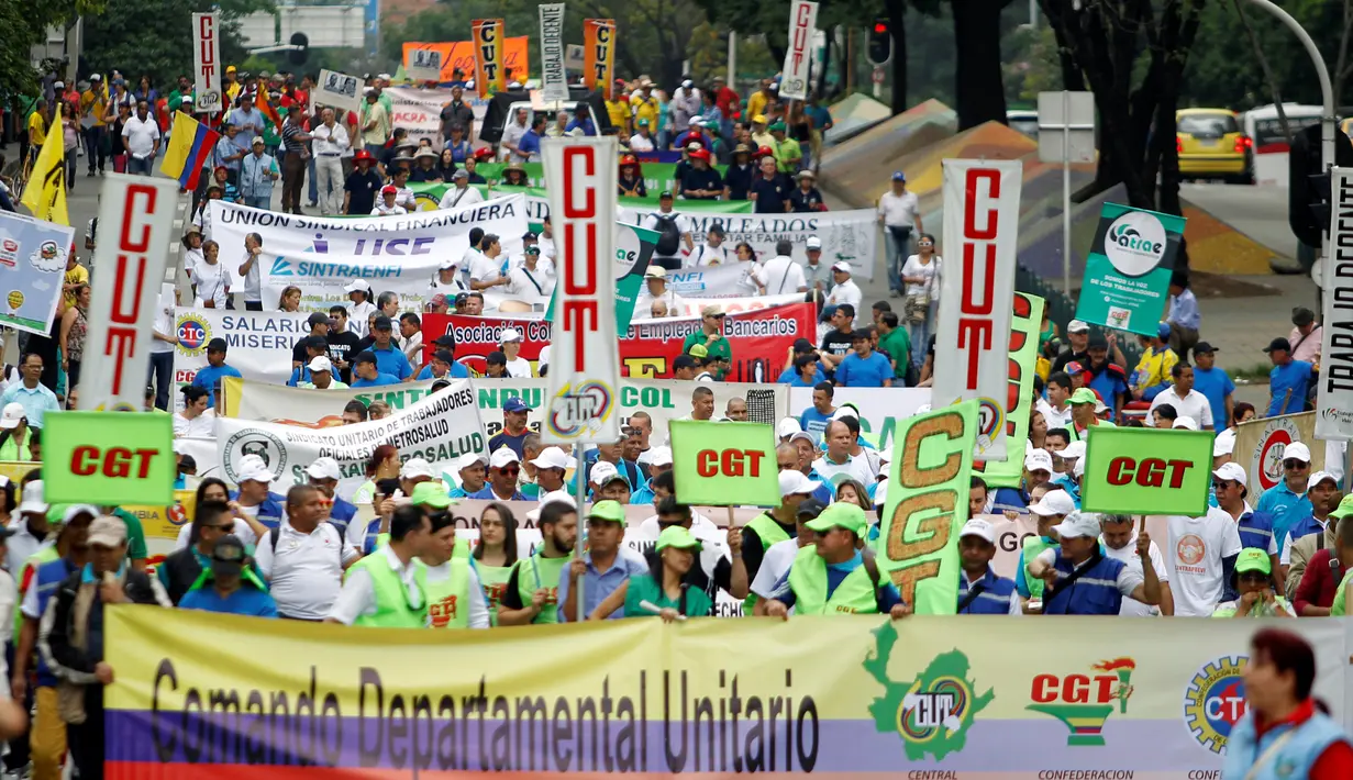 Pengunjuk rasa membawa berbagai atribut saat ambil bagian dalam peringatan May Day 2016 atau Hari Buruh Sedunia di Medellin, Kolombia, Minggu (1/5). Di beberapa negara, peringatan buruh sempat diwarnai dengan aksi bentrok. (REUTERS/Fredy Builes)