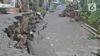 Warga melintasi sisi ruas jalan yang ambles di Jalan Kesatria, Matraman, Jakarta, Selasa (3/3/2020). Hujan lebat yang mengguyur Ibu Kota beberapa waktu lalu mengakibatkan ruas jalan sepanjang 100 meter di kawasan tersebut retak dan ambles. (Liputan6.com/Herman Zakharia)