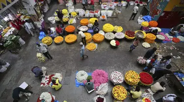 Penjual bunga menunggu pembeli di pasar grosir di Bengaluru, India, Kamis (24/9/2020). Negara berpenduduk 1,3 miliar itu diperkirakan akan menjadi negara terparah pandemi COVID-19 dalam beberapa minggu, melampaui Amerika Serikat. (AP Photo/Aijaz Rahi)
