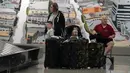<p>Pelancong menunggu barang mereka di area pengambilan bagasi di Bandara Internasional Los Angeles, Senin (25/4/2022). Seminggu sebelumnya, seorang hakim federal di Florida menolak persyaratan untuk memakai masker di bandara dan selama penerbangan. Aturan itu, yang dirancang untuk membatasi penyebaran COVID-19, akan berakhir pada 3 Mei. (AP Photo/Marcio Jose Sanchez)</p>