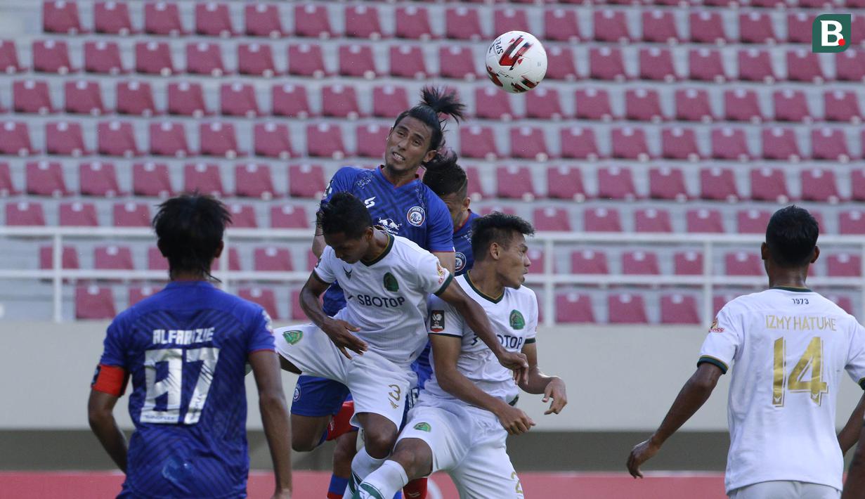 Bek Persikabo 1973, Andy Setyo Nugroho (kanan) berduel udara dengan bek Arema FC, Hanif Sjahbandi (atas) dalam laga pembuka Piala Menpora 2021 di Stadion Manahan, Solo, Minggu (21/3/2021). Persikabo 1973 bermain imbang 1-1 dengan Arema FC. (Bola.com/M Iqbal Ichsan)
