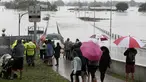 Warga menyaksikan banjir Sungai Hawkesbury di Windsor, barat laut Sydney, New South Wales, Australia (22/3/2021). Negara bagian New South Wales yang padat penduduknya telah mengeluarkan lebih banyak perintah evakuasi menyusul banjir terburuk dalam beberapa dekade. (AP Photo/Rick Rycroft)