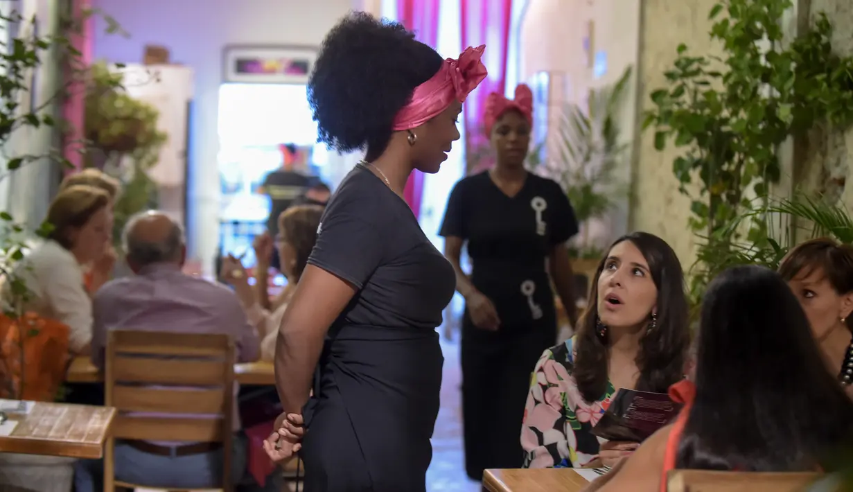 Seorang narapidana wanita melayani pelanggan di restoran Interno di Cartagena, Kolombia (24/8). Interno ini merupakan restoran pertama di Kolombia yang berada di dalam area penjara. (AFP Photo/Raul Arboleda)