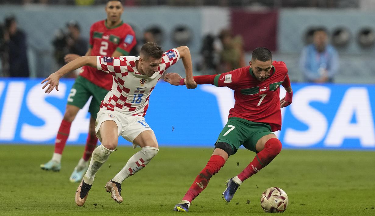 <p>Gelandang Maroko, Hakim Ziyech mengontrol bola dari kawalan pemain Kroasia, Mislav Orsic selama pertandingan playoff perebutan juara ketiga Piala Dunia 2022 di Khalifa International Stadium di Doha, Qatar, Sabtu (17/12/2022). Kroasia meraih juara ketiga Piala Dunia 2022 usai menang 2-1 atas Maroko. (AP Photo/Thanassis Stavrakis)</p>