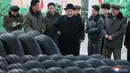 Pemimpin Korut, Kim Jong-un berbincang dengan para pekerja di pabrik ban lokal di di Chagang, Korut (3/11). Kim Jong-un tampil dengan mengenakan jas dan topi hitam saat mengunjungi pabrik ban tersebut. (KCNA/via AP)