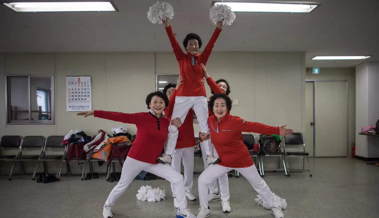 Sejumlah anggota cheerleaders Cheer Mommy berpose saat latihan rutin di ruang latihan di Samcheok, Korsel (3/3). Dengan penuh semangat sekumpulan wanita lanjut usia mempraktekan gerakan layaknya seorang pemandu sorak. (AFP/Ed Jones)