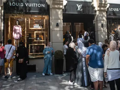 Turis asing, terutama dari Arab Saudi dan Asia, mengantre di luar toko barang mewah, Louis Vuitton di Istanbul, 13 Agustus 2018. Anjloknya mata uang Lira mendatangkan keuntungan bagi para turis yang melancong ke Turki. (AFP/Yasin AKGUL)