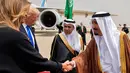 Melania Trump (kiri) berjabat tangan dengan Raja Arab Saudi Salman bin Abdulaziz al-Saud saat di Bandara Internasional Raja Khalid di Riyadh (20/5). (AFP/Saudi Royal Palace/Bandar Al-Jalou)